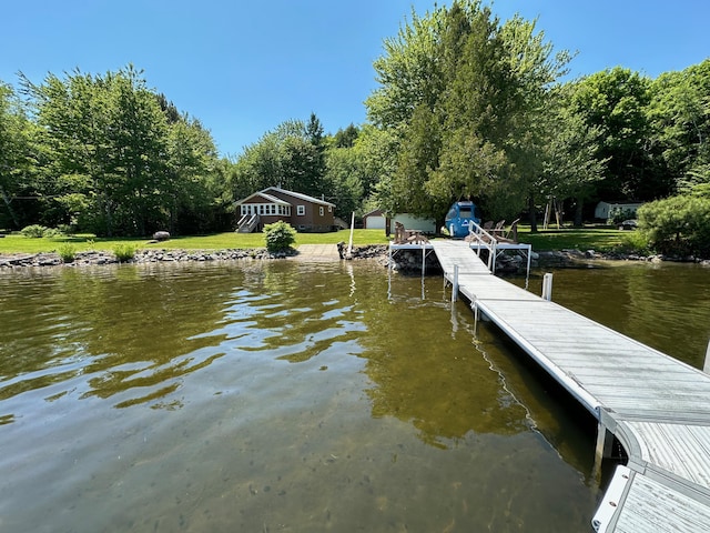 dock area with a yard and a water view