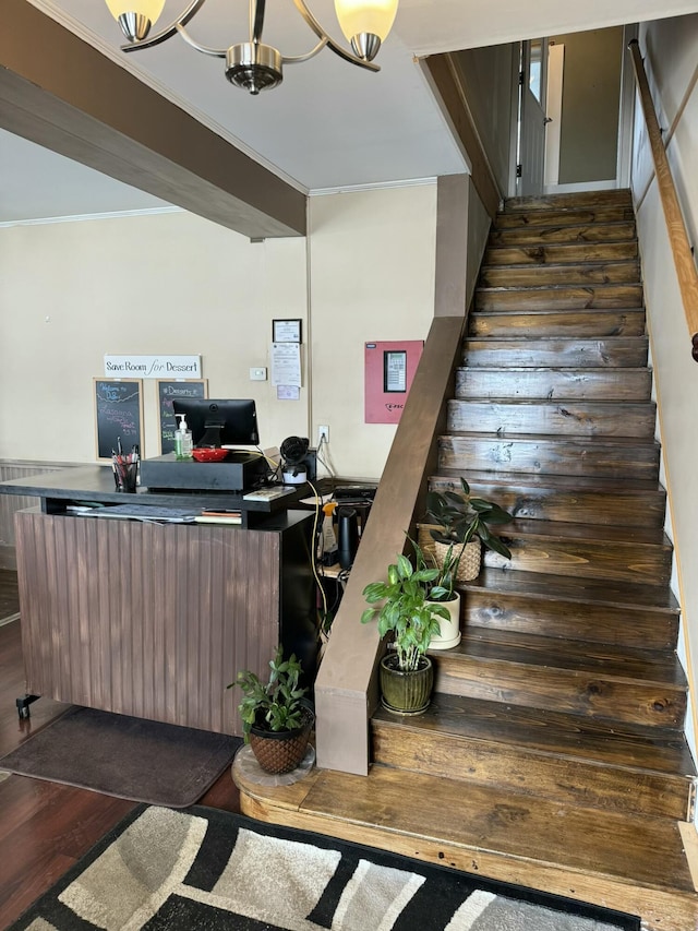 interior space featuring wood finished floors, a notable chandelier, and ornamental molding