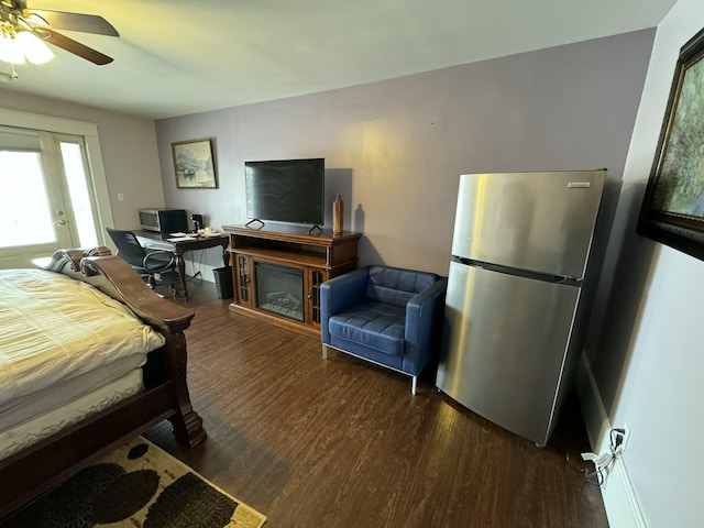 bedroom with wood finished floors, freestanding refrigerator, and a ceiling fan