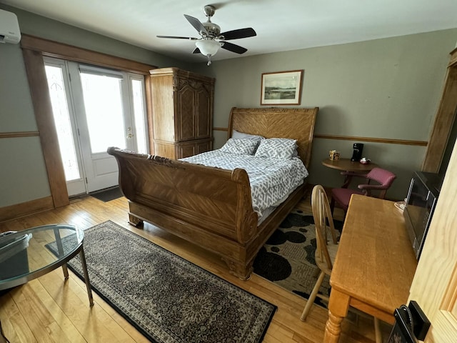 bedroom featuring light wood finished floors, an AC wall unit, access to outside, and ceiling fan