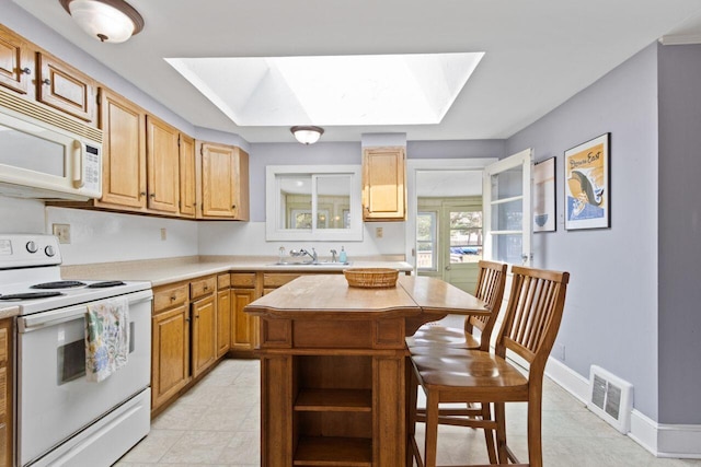 59 Brigham St, South Portland, ME 04106 - kitchen with a sink, white appliances, visible vents, light countertops, and a skylight