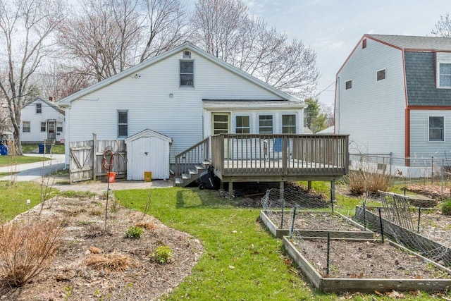 59 Brigham St, South Portland, ME 04106 - rear view of property with a deck, a garden, a storage unit, fence, and a lawn