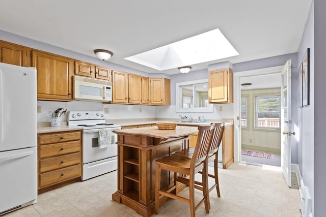 59 Brigham St, South Portland, ME 04106 - kitchen featuring a baseboard heating unit, white appliances, a kitchen island, light countertops, and a skylight