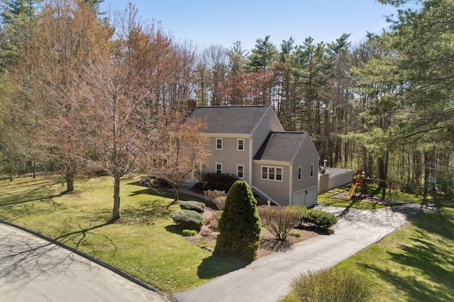 19 Windsor Pines Dr, Scarborough, ME 04074 - view of front of house featuring concrete driveway, a chimney, a front yard, and a garage