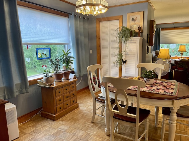dining space featuring an inviting chandelier, crown molding, and baseboards