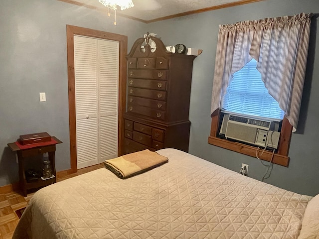 bedroom with baseboards, crown molding, and a closet