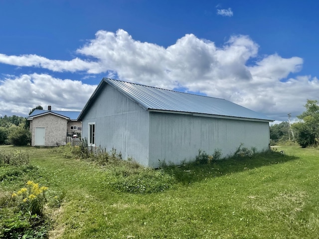 view of side of property with a yard and metal roof