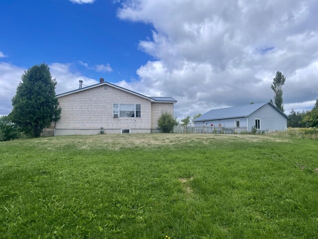 view of side of home featuring a yard and metal roof