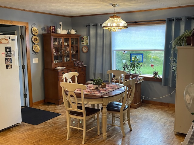 dining space with baseboards, a chandelier, and ornamental molding