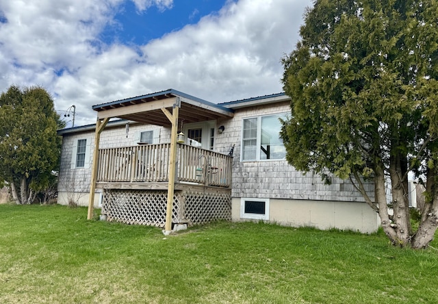 back of house with a yard, a deck, and metal roof
