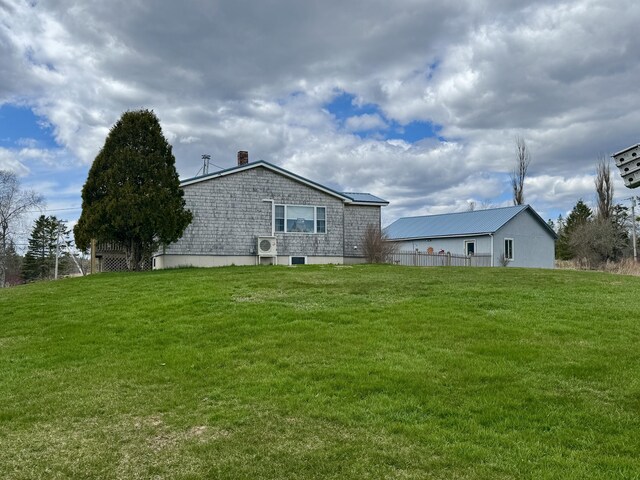 back of property with a lawn, ac unit, and a chimney
