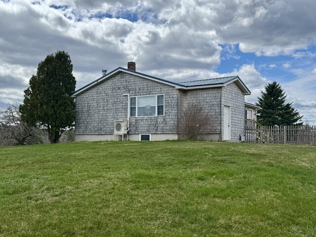 back of property with a chimney, fence, ac unit, and a yard