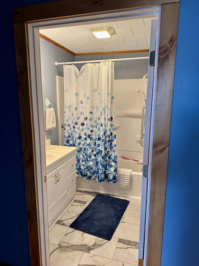 full bath featuring shower / bath combination with curtain, marble finish floor, vanity, and crown molding