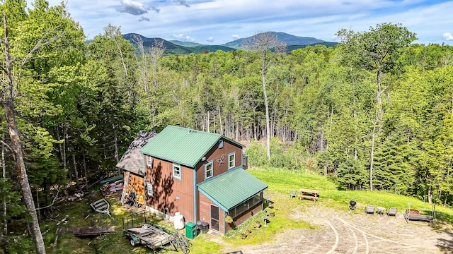drone / aerial view with a wooded view and a mountain view