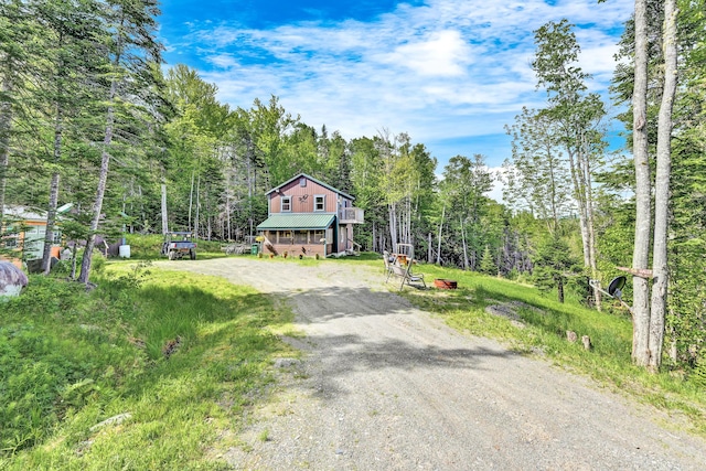 view of road with a view of trees and driveway