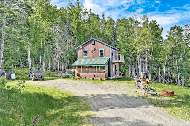rustic home with metal roof and a forest view