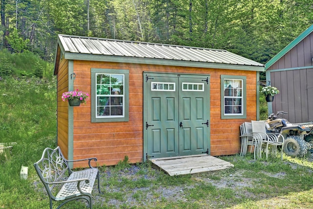 view of shed with a wooded view