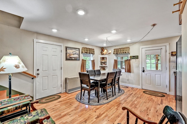 dining area with recessed lighting, baseboards, light wood-type flooring, and a chandelier