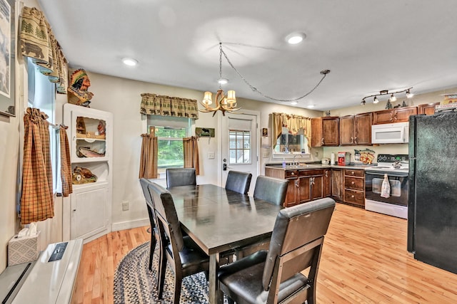 dining room with light wood-style floors, recessed lighting, and a notable chandelier