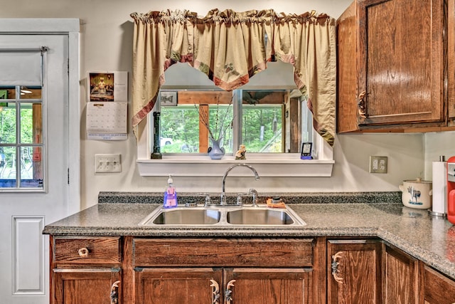 kitchen with plenty of natural light, a sink, and dark countertops