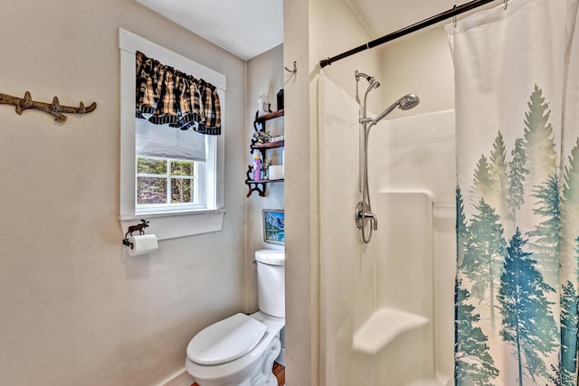 bathroom with toilet and a shower with shower curtain