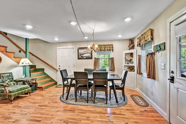 dining room featuring an inviting chandelier, light wood-style floors, stairs, and a wealth of natural light