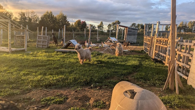 yard at dusk with exterior structure, an outdoor structure, and fence