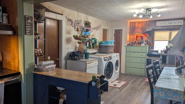 kitchen with butcher block countertops, light wood-style flooring, electric range, blue cabinetry, and washing machine and dryer