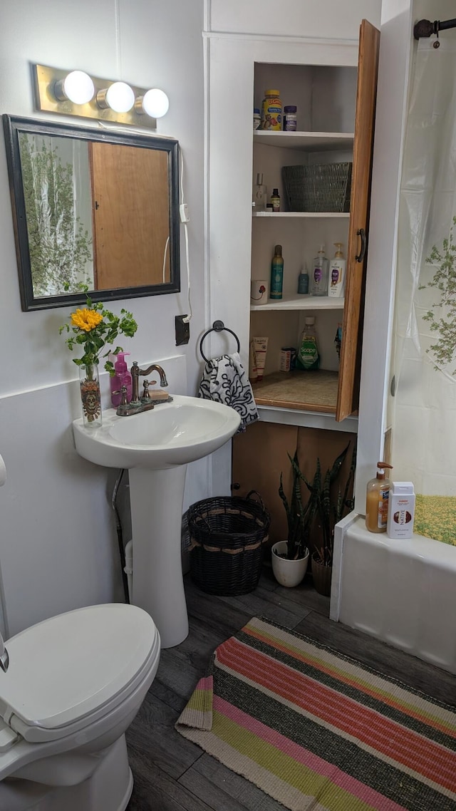 full bath with toilet, wood finished floors, and curtained shower