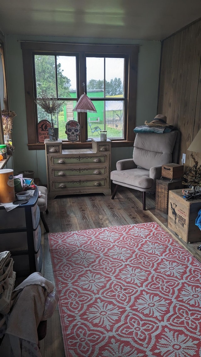 living area featuring dark wood-type flooring and wood walls