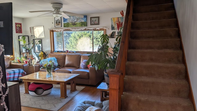living room featuring wood finished floors, stairs, and ceiling fan