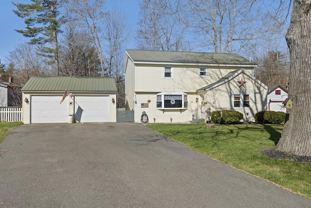 colonial home with an outdoor structure, fence, and a front yard