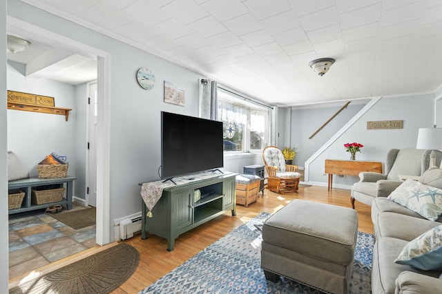 living room featuring light wood-style flooring, baseboard heating, and crown molding