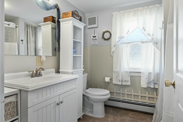 full bathroom with a baseboard heating unit, toilet, vanity, and visible vents