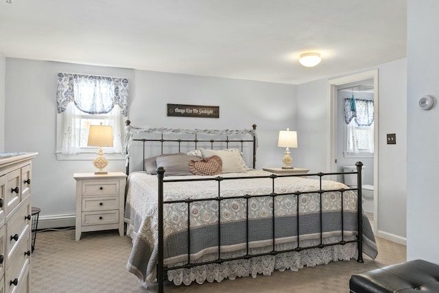 carpeted bedroom with a baseboard heating unit, baseboards, and multiple windows