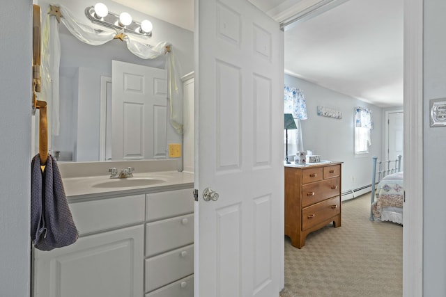 ensuite bathroom featuring a baseboard heating unit, ensuite bath, and vanity