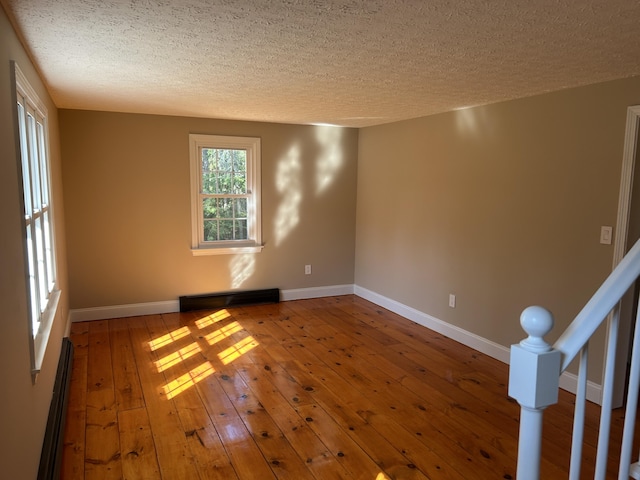 7 Kathryn St, Gorham, ME 04038 - unfurnished room with baseboards, a baseboard radiator, wood-type flooring, and a textured ceiling