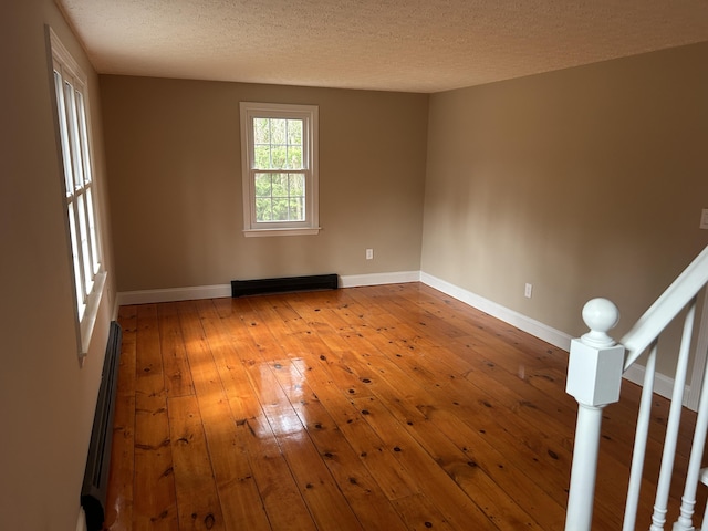 7 Kathryn St, Gorham, ME 04038 - spare room with a textured ceiling, baseboard heating, baseboards, a baseboard heating unit, and hardwood / wood-style floors