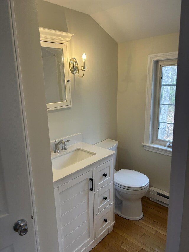 7 Kathryn St, Gorham, ME 04038 - half bathroom with baseboard heating, vaulted ceiling, wood finished floors, vanity, and toilet