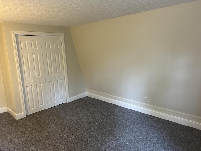 7 Kathryn St, Gorham, ME 04038 - unfurnished bedroom with dark colored carpet, a textured ceiling, baseboards, and a closet
