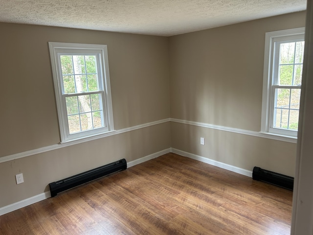 7 Kathryn St, Gorham, ME 04038 - empty room featuring plenty of natural light, a baseboard radiator, baseboards, and wood finished floors