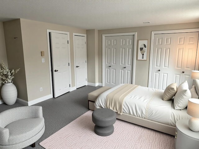 7 Kathryn St, Gorham, ME 04038 - bedroom featuring a textured ceiling, baseboards, multiple closets, and dark colored carpet