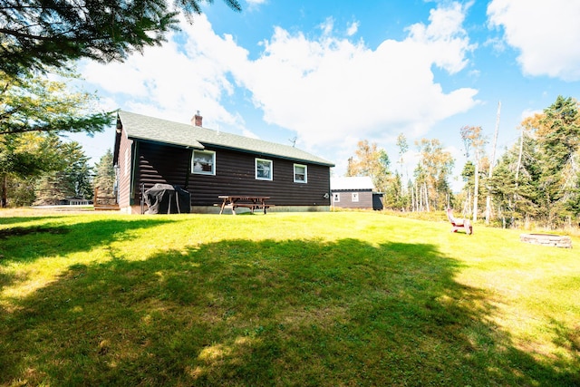 90 Manor Dr, Rangeley, ME 04970 - rear view of property featuring a chimney and a yard