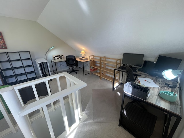 carpeted home office with vaulted ceiling