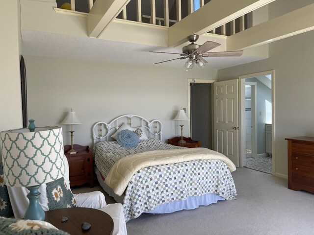 carpeted bedroom featuring connected bathroom, a ceiling fan, and a towering ceiling