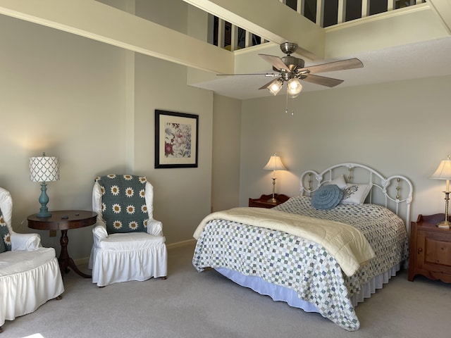 bedroom featuring ceiling fan, carpet floors, a towering ceiling, and baseboards