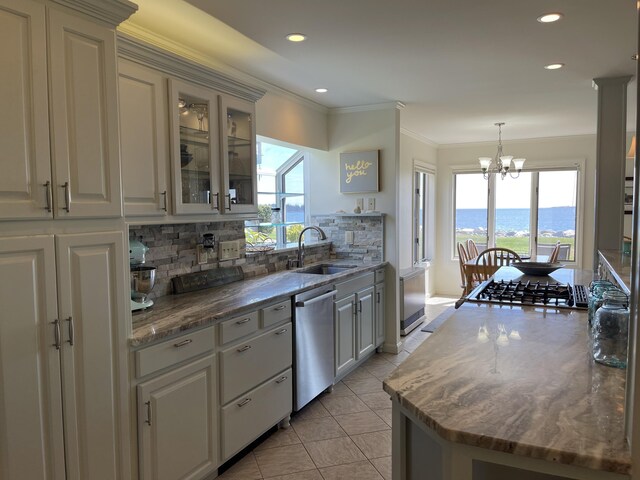 kitchen with stainless steel dishwasher, a sink, tasteful backsplash, recessed lighting, and a notable chandelier