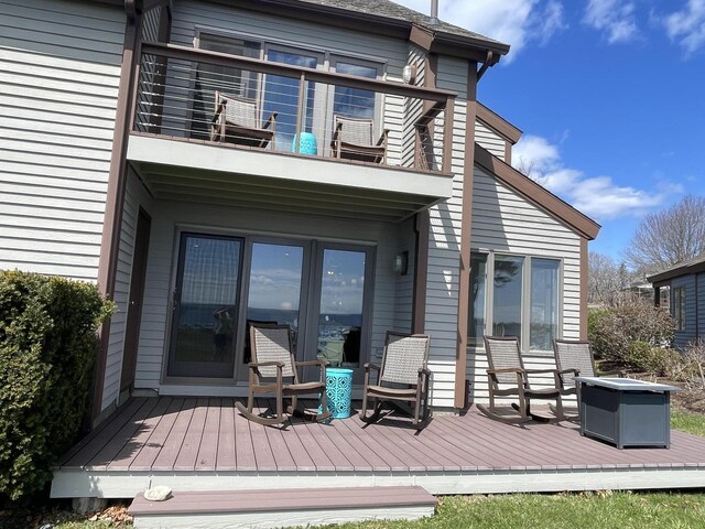 back of property featuring a balcony and a deck