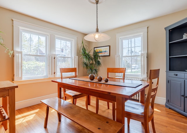 dining room featuring a healthy amount of sunlight, baseboards, and light wood-style flooring