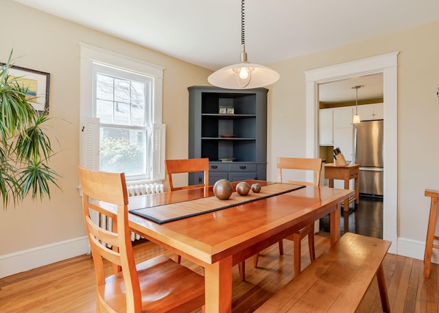 dining space with baseboards and light wood-style floors